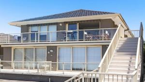 瓦布利尔On The Beach #13 Beachfront, Ocean Views Accom Holidays的带阳台和楼梯的大型房屋