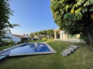 a yard with a swimming pool and a house at Casa Tabachin in Alpuyeca