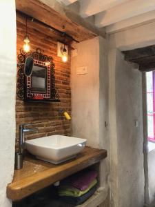 baño con lavabo y TV en la pared en Grande maison familiale, rustique et charmante en Bourgogne, dans le Morvan, en Dun-sur-Grandry