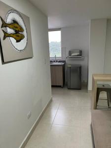 Habitación con cocina con una foto de un pez en la pared en Urban 102, en Manizales