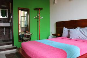 a bedroom with a bed and a green wall at Hotel Guaranducha Inn in Campeche