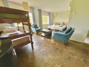 Champagne Valley的住宿－Drakensberg Inkosana Lodge，一间带双层床的卧室和一间带沙发的客厅