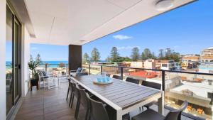 a balcony with a table and chairs and a view of the ocean at Oceans Edge #7 Accom Holidays in Terrigal