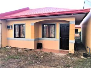 una piccola casa gialla e arancione con una porta nera di Affordable Whole House Rent Transient a Butuan