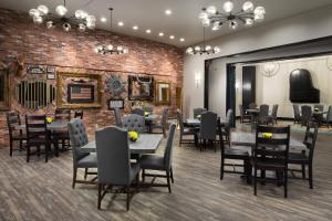un ristorante con tavoli e sedie e un muro di mattoni di Sheraton Oklahoma City Downtown Hotel a Oklahoma City