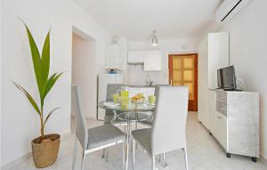 eine Küche und ein Esszimmer mit einem Tisch und Stühlen in der Unterkunft Cozy Apartment In Rabac With Kitchen in Rabac