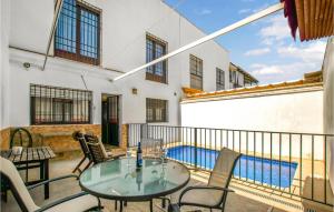 balcón con mesa, sillas y piscina en 4 Bedroom Nice Home In Villarrubia, en Villarrubia