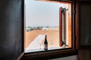 - une fenêtre avec une bouteille de vin et 2 verres dans l'établissement Kristinas View Studios, à Rhodes