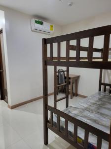Zimmer mit einem Etagenbett und einem Tisch in der Unterkunft Dormitory near SM and S and R in Davao City