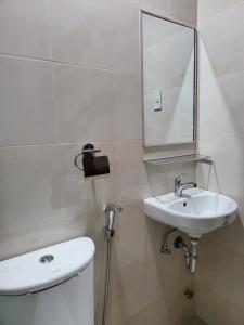 y baño con aseo, lavabo y espejo. en Dormitory near SM and S and R en Dávao
