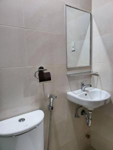 y baño con aseo, lavabo y espejo. en Dormitory near SM and S and R en Davao