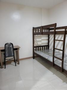 Zimmer mit 2 Etagenbetten und einem Schreibtisch in der Unterkunft Dormitory near SM and S and R in Davao City