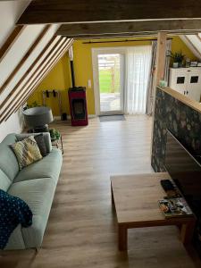uma sala de estar com um sofá e uma mesa em Hústerheide em Noordbergum
