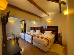1 dormitorio con 2 camas, mesa y escritorio en Mistico San Blas Boutique, en Cusco