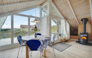 uma sala de jantar com uma mesa e cadeiras e uma lareira em Beautiful Home In Hvide Sande With 2 Bedrooms, Sauna And Wifi em Havrvig
