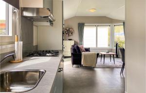 een keuken en een woonkamer met een kookplaat. bij Gorgeous stacaravan In Julianadorp With House A Panoramic View in Julianadorp
