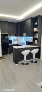 a kitchen with a counter and two stools at D&Q METROCITY GUESTHOUSE in Kuching