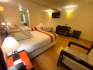Habitación de hotel con cama y sala de estar. en Mistico San Blas Boutique, en Cusco