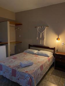 um quarto com uma cama com duas almofadas em Pousada do Suiço em Fortaleza