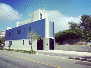 een blauw-wit gebouw aan de straatkant bij Sky Blue Villa沖縄 in Jima