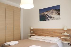パレルモにあるAppartamenti-Residence Al Massimoのベッドルーム1室(木製ヘッドボード付きのベッド1台付)