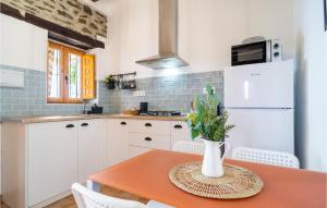 a kitchen with a table and a white refrigerator at Lovely Home In Adra With Kitchenette in Adra