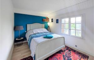 1 dormitorio con 1 cama con pared azul en Nice Home In tigny With Wifi, en Étigny