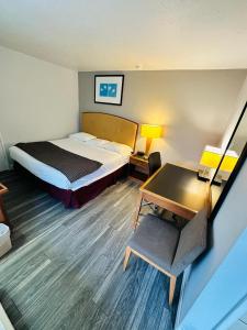 Cette chambre comprend un lit et un bureau. dans l'établissement Travel Inn & Suites, à Emporia