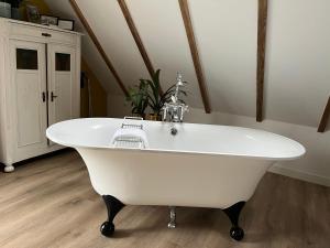 bañera blanca en una habitación con lavabo en Hústerheide en Noordbergum
