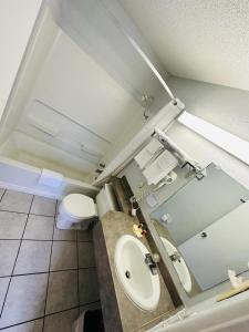 a small bathroom with a toilet and a sink at Travel Inn & Suites in Emporia