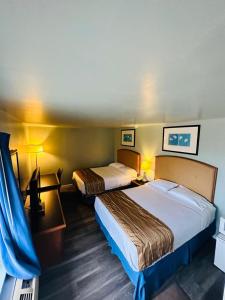 Cette chambre comprend deux lits et un bureau. dans l'établissement Travel Inn & Suites, à Emporia