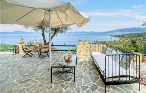 a patio with an umbrella and a table at 2 Bedroom Lovely Home In Kalamata in Kalamata