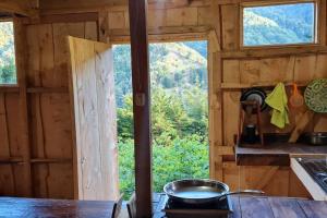 uma panela no fogão numa sala com uma janela em Cabaña El Descanso #1, Macho Mora Mountain Lodge em Alaska