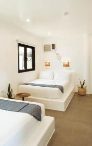 2 camas en una habitación con paredes blancas en Hostel Bajala Siargao, en General Luna