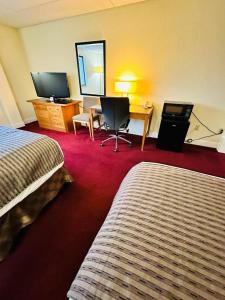 a hotel room with two beds and a desk at Travel Inn & Suites in Emporia