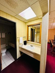 a bathroom with a sink and a toilet at Travel Inn & Suites in Emporia