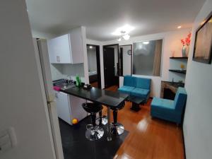 cocina y sala de estar con mesa y sillas azules en Apartemento Céntrico Luminoso en Pasto