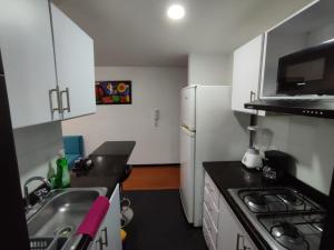 uma pequena cozinha com um lavatório e um frigorífico em Céntrico luminoso y equipado apto em Pasto