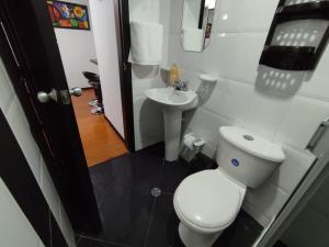 a small bathroom with a toilet and a sink at Céntrico luminoso y equipado apto in Pasto