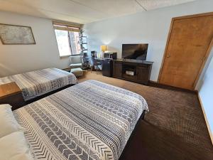 a hotel room with two beds and a flat screen tv at Village square 442 Center Village Copper Mountain in Copper Mountain