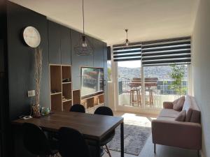 a living room with a table and a couch at Departamento con piscina vista panorámica in Coquimbo
