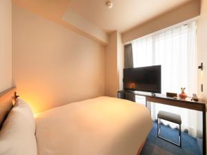 福岡的住宿－QuintessaHotel FukuokaHakata Relax&Sleep，一间卧室配有一张床和一台平面电视
