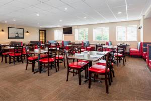 uma sala de jantar com mesas e cadeiras vermelhas em Four Points by Sheraton Milwaukee Airport em Milwaukee