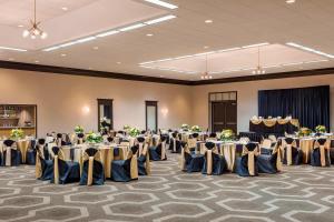 um salão de banquetes com mesas e cadeiras numa sala em Four Points by Sheraton Milwaukee Airport em Milwaukee