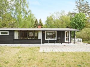 Holiday home Rørvig XIII في Rørvig: منزل أسود أمامه فناء