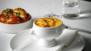 a white bowl of food on a table with a bowl of food at InterContinental Bangkok by IHG in Bangkok