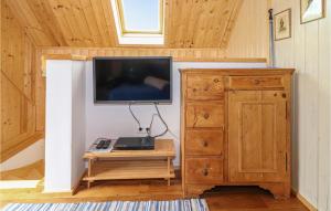 a living room with a tv and a wooden cabinet at Amazing Home In Strem With Wifi in Strem