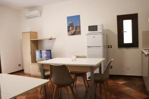 a small kitchen with a white table and chairs at Appartamenti-Residence Al Massimo in Palermo