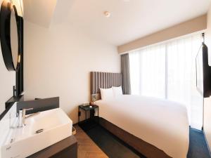福岡的住宿－QuintessaHotel FukuokaHakata Relax&Sleep，浴室设有白色的床和水槽。