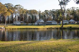 a row of houses next to a lake at The Leaning Oak Holiday Lifestyles - Lake Conjola in Conjola
